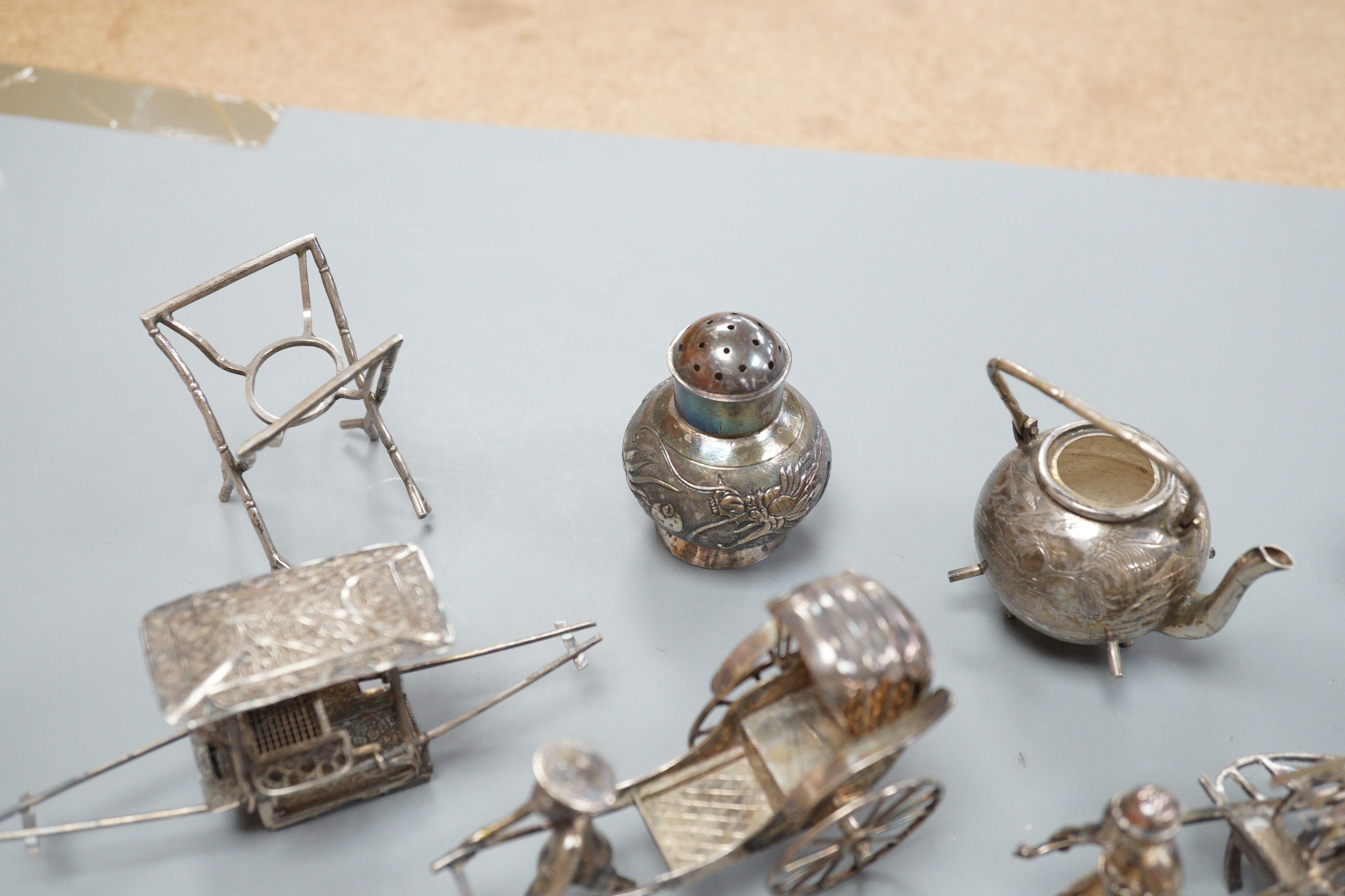 Six assorted miniature white metal items including a Chinese tea kettle on stand (lacking lid), height 93mm, maker CS, a similar rickshaw with driver, maker CH, a Chinese condiment and three other items.